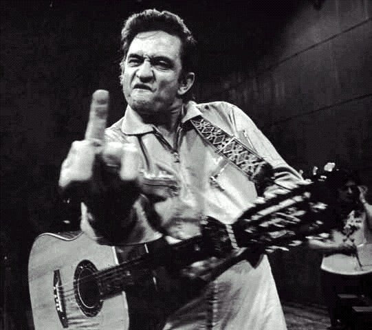 Johnny Cash flipping off the camera from his concert in Folsom County prison.