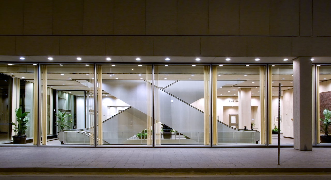 Modern building facade with large glass windows reflecting interior details